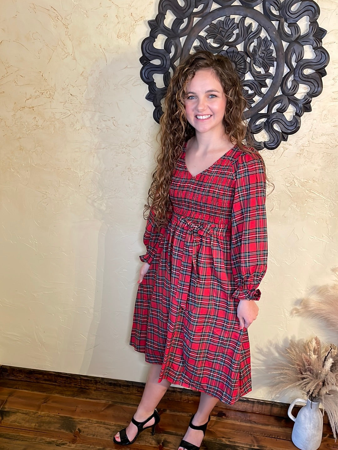 Red Tartan Plaid A-line dress. Long balloon sleeve ruffled wrist accent. Smocked bodice. Model wearing size small.