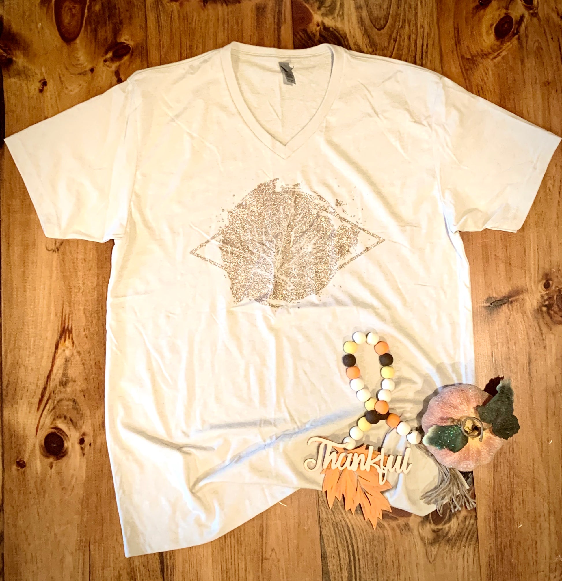 cream color graphic tee with glitter maple leaf deign in front center