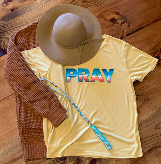 Pray- With Serape print appliqué graphic tee. Soft comfortable material with a feminine fit. Mustard Yellow.